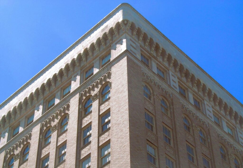 Corner view of a historic building showcasing intricate architectural details against a clear sky.